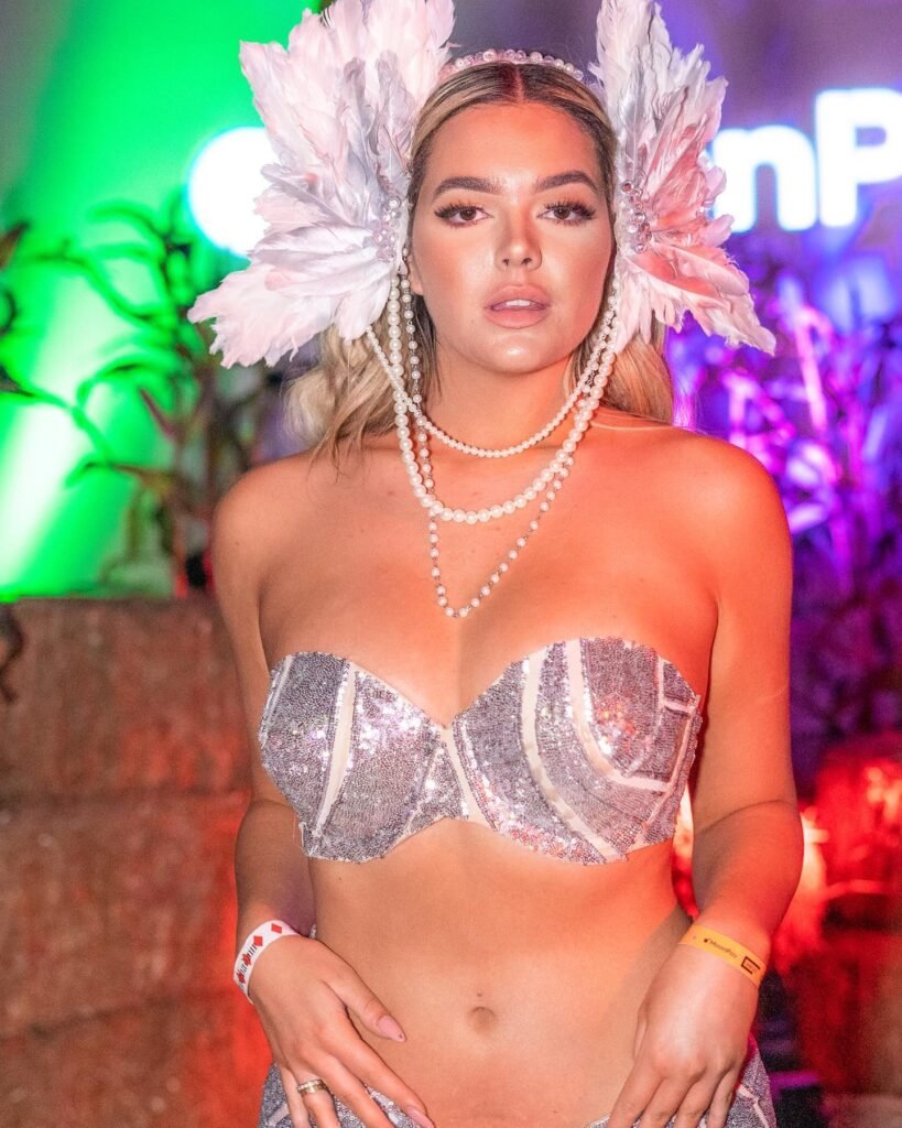 persian model with long dark hair wearing a red evening gown looking into camera