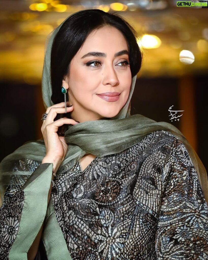 persian model with long dark hair wearing a white lace dress looking into camera