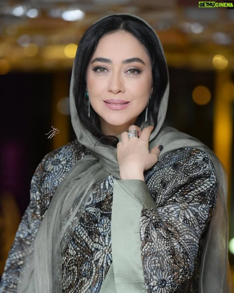 persian model with long dark hair wearing a white lace dress looking into camera