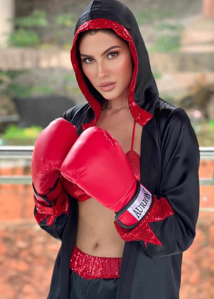 persian model with long dark hair wearing a white top and blue jeans looking into camera