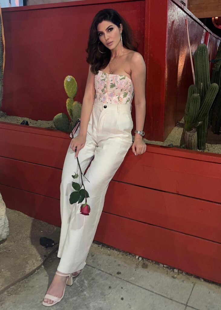 persian model with long dark hair wearing a beige outfit looking into camera