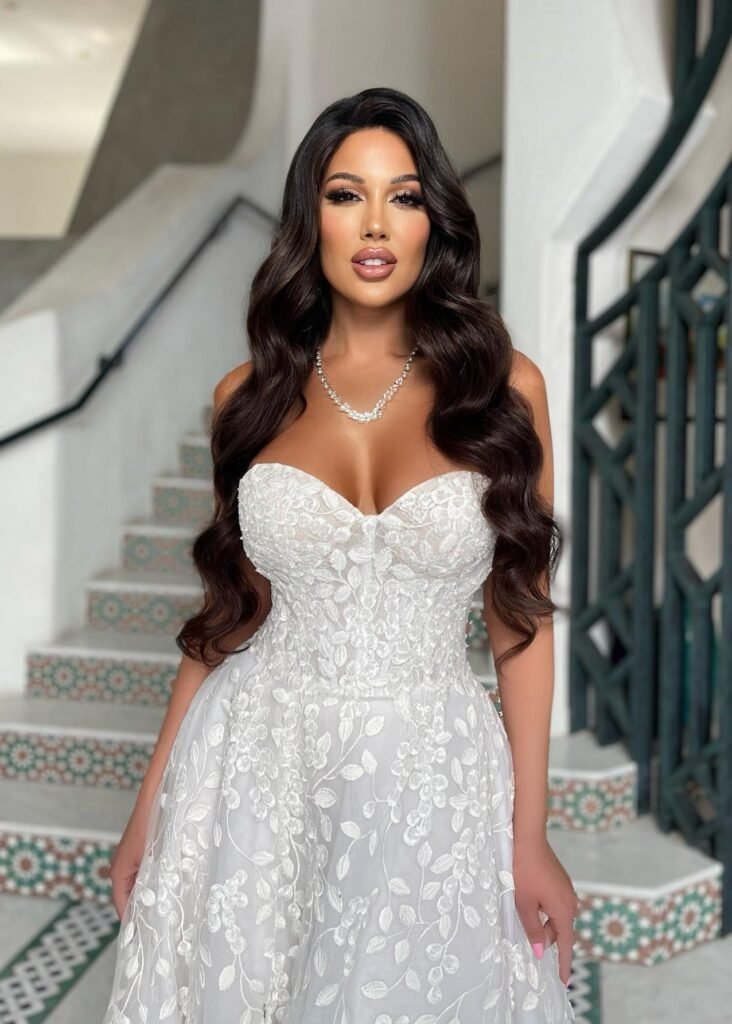 persian model with long dark hair wearing a charcoal gray knit dress looking into camera