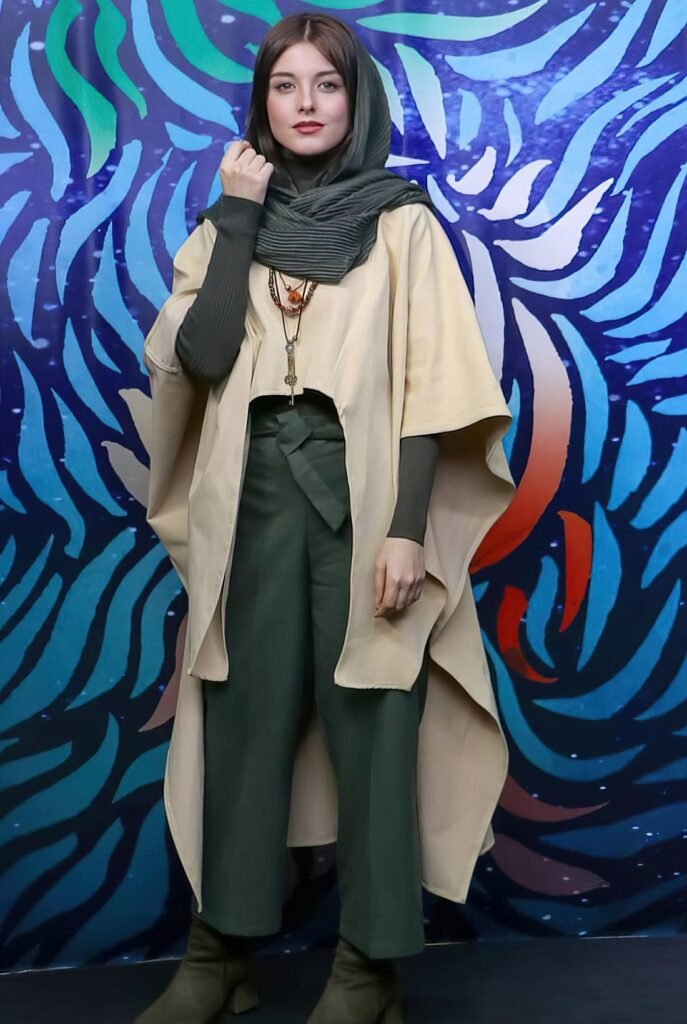 persian actress with long dark hair wearing a black silk headscarf and matching outfit posing outdoors