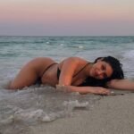 persian model with long dark hair wearing a gray tailored blazer looking into camera with a professional look