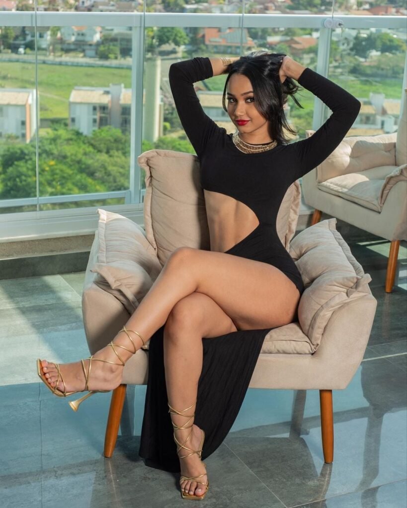 persian model with long dark hair wearing a white sleeveless top and gold bracelet looking into camera