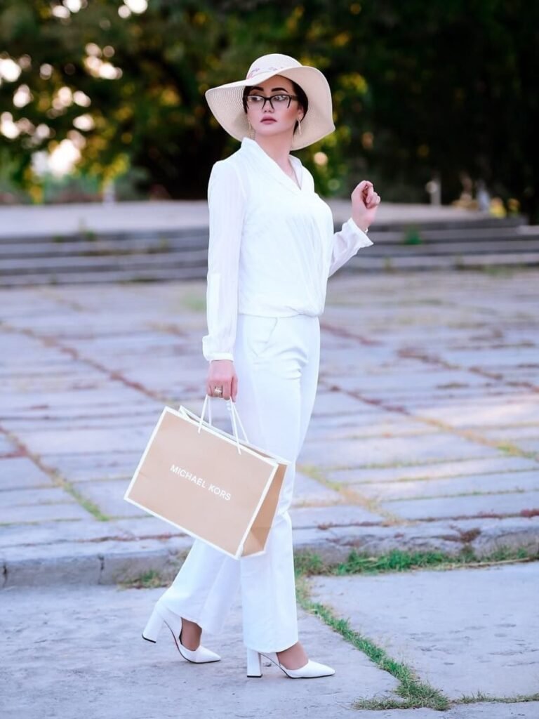 persian model with long dark hair smiling while looking into camera wearing a black top and silver earrings