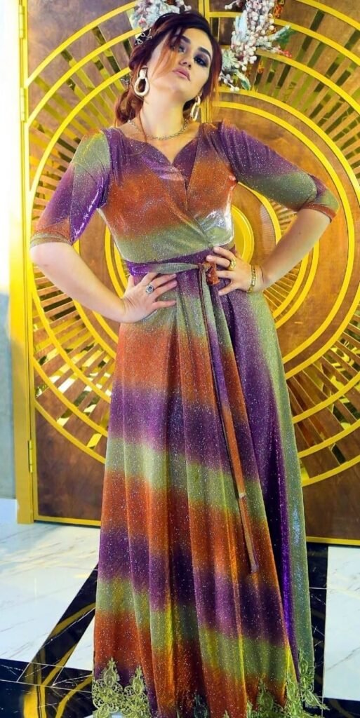 persian model with long dark hair looking into camera wearing a black top and silver earrings